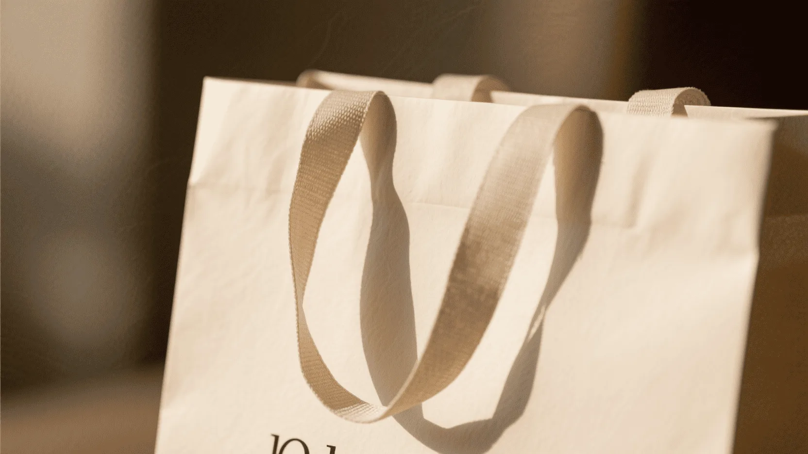 A close-up shot focusing on the high-quality paper texture and sturdy, comfortable handle of a custom bag.