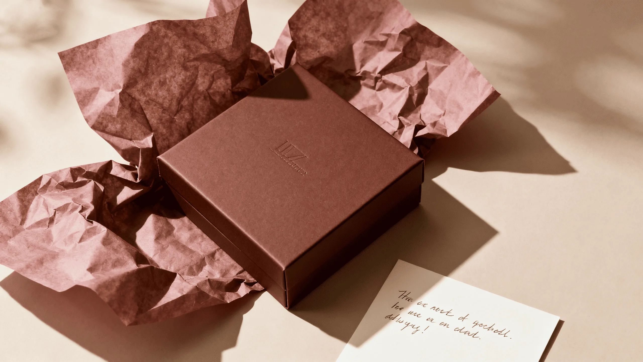 An overhead shot of a perfectly arranged unboxing scene, with the chocolate box, tissue paper, and a personalized note creating a visually appealing flat lay.
