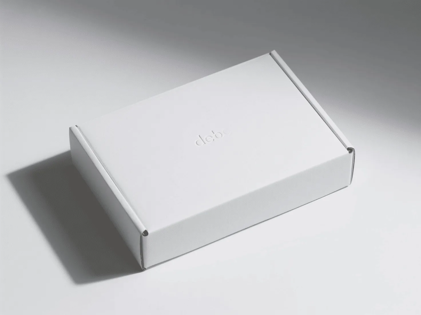 A clean, white box with a simple debossed logo, casting a subtle shadow.