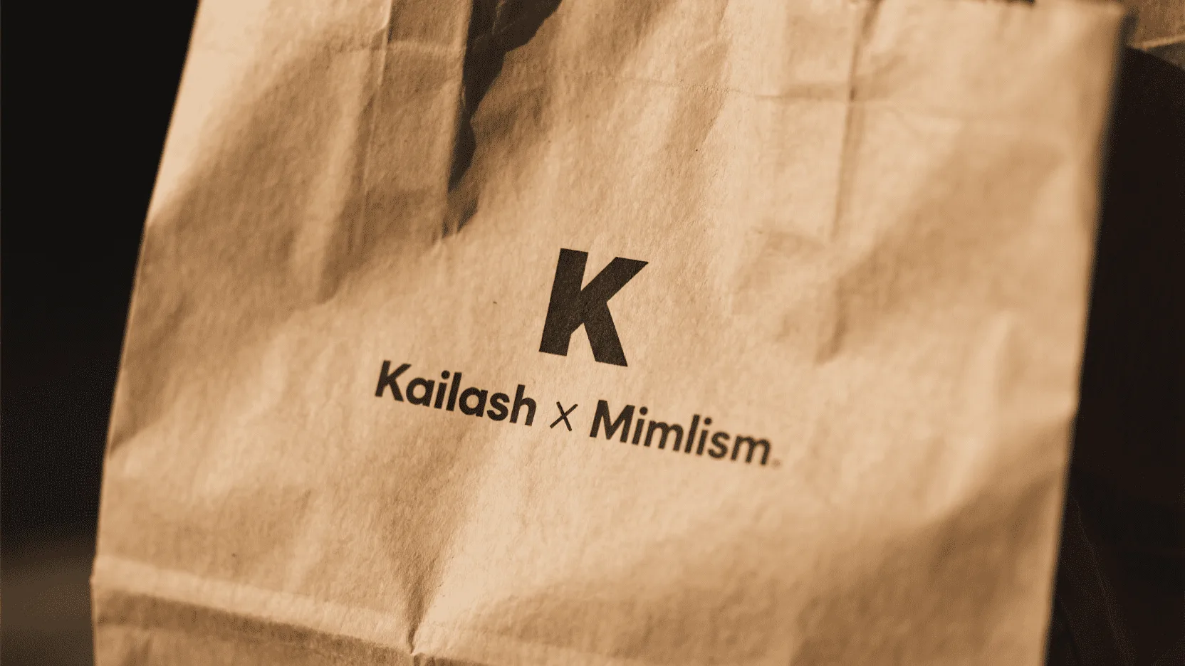 A close-up shot of a custom logo printed with black soy-based ink on a brown kraft paper bag.