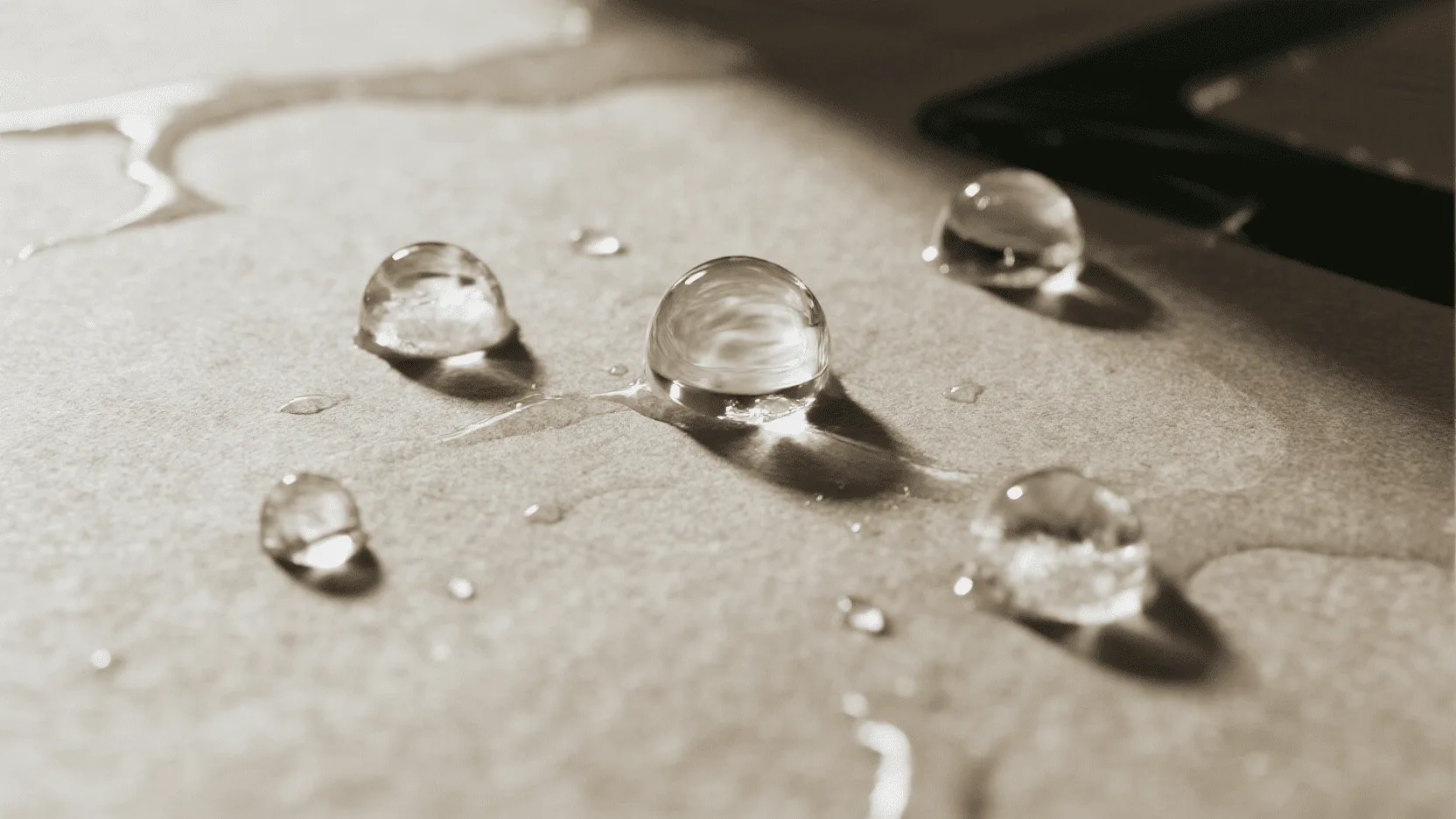 A close-up shot of water beading on the surface of a coated paper bag, demonstrating its protective barrier.
