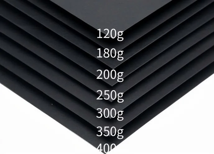 A hand holding several paper samples of different thicknesses, fanned out
